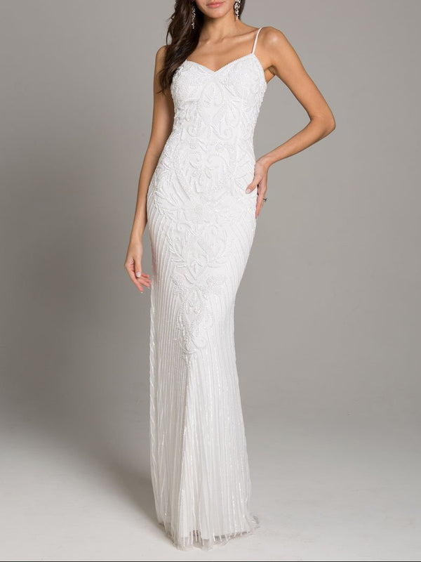 A woman wearing a white long dress with beads and sequins, featuring a sweetheart neckline and spaghetti straps.