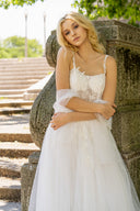 A bride in a stunning wedding dress poses in front of classic columns, capturing the essence of her special day.