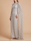 Woman wearing a silver glittery dress with a beige background