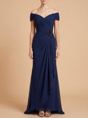 A woman modeling an off-the-shoulder navy blue floor-length gown with ruching and bead embellishment at the waist, photographed against a solid beige studio background.