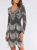 A woman wears the Lara 29377 Long Sleeve Beaded V-Neck Fringe Cocktail Dress, featuring black tulle, silver patterns, and art deco-inspired fringe details that capture the glamorous spirit of the roaring 20s.