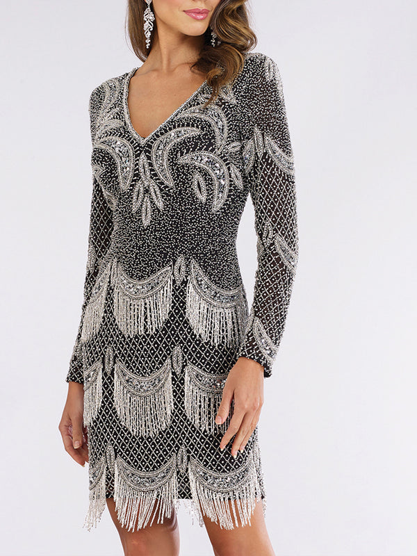 A woman wears the Lara 29377 Long Sleeve Beaded V-Neck Fringe Cocktail Dress, featuring black tulle, silver patterns, and art deco-inspired fringe details that capture the glamorous spirit of the roaring 20s.