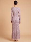 A model viewed from the back wearing a floor-length lavender gown with intricate beaded swirl patterns and a fitted silhouette, set against a solid beige studio background.