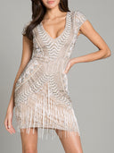 A woman poses confidently in the Lara Brooklyn Beaded Fitted Short Dress with an open back, featuring short sleeves, silver geometric accents on beige beading, a deep V-neckline, and fringe hem—perfect for a chic bridal shower.
