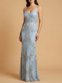 Woman wearing a light blue lace evening gown against a beige background