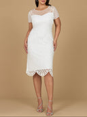 A model wearing a white beaded midi dress with cap sleeves and a sheer neckline.