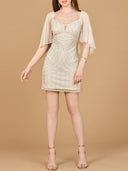 Woman wearing a beige lace dress with sheer sleeves on a beige background