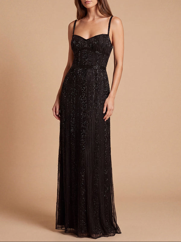 Woman wearing a black lace evening gown against a beige background