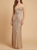 Woman wearing a sparkly gold evening gown against a beige background